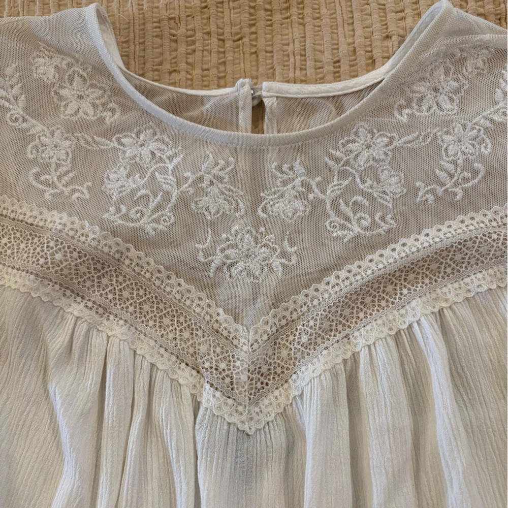 This is a beautiful Torrid white short sleeve shirt with lace details.